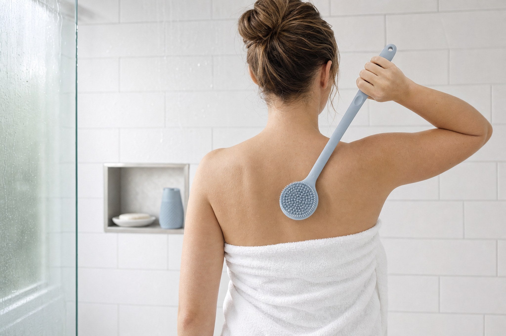 אישה עטופה במגבת מגיעה עם Brush Body לכל הגב